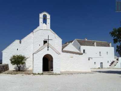 Spiccano anche la grande croce in ferro che sormonta l'ingresso...